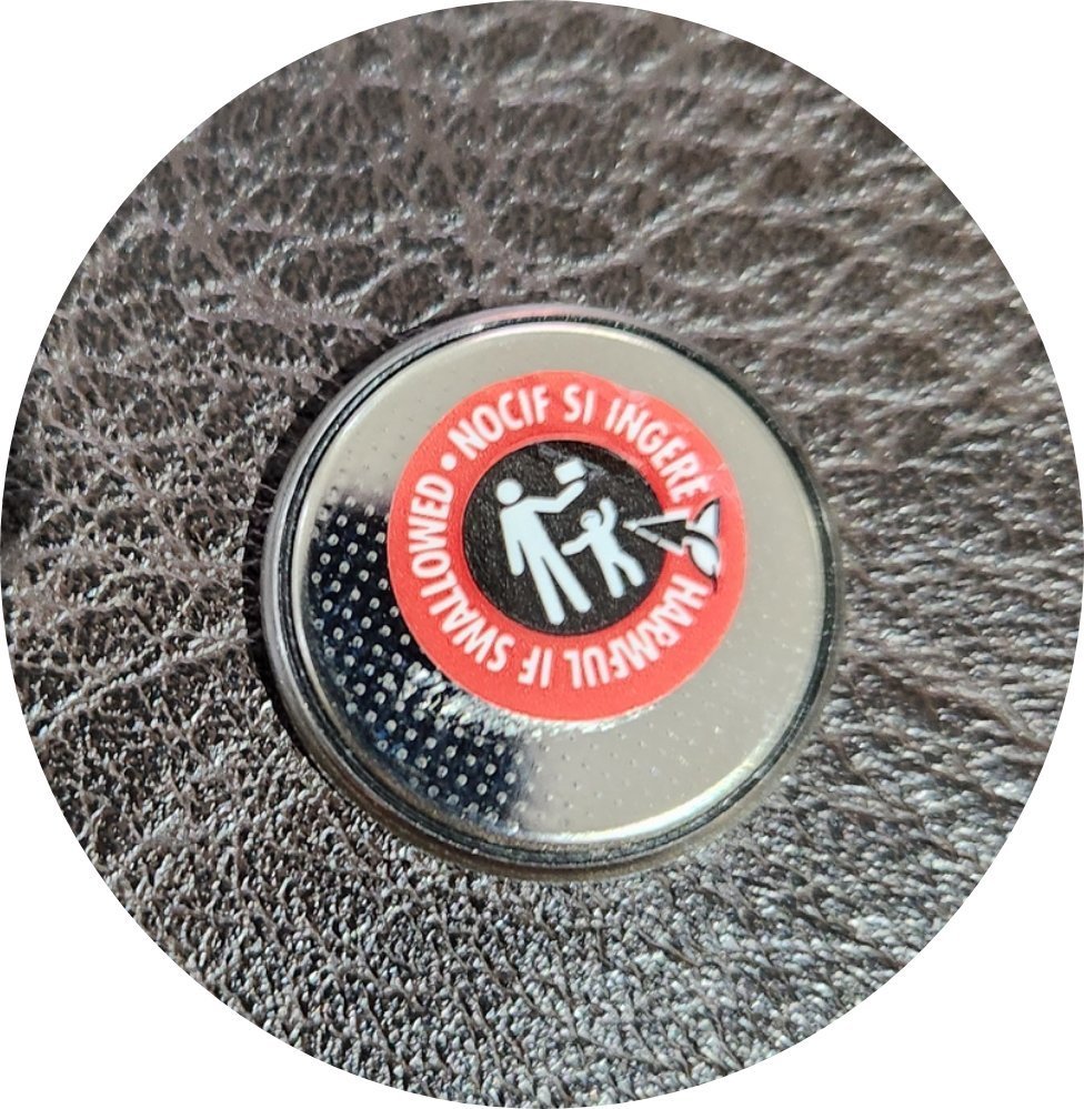 CR2032 coin cell showing removable clear sticker on negative side